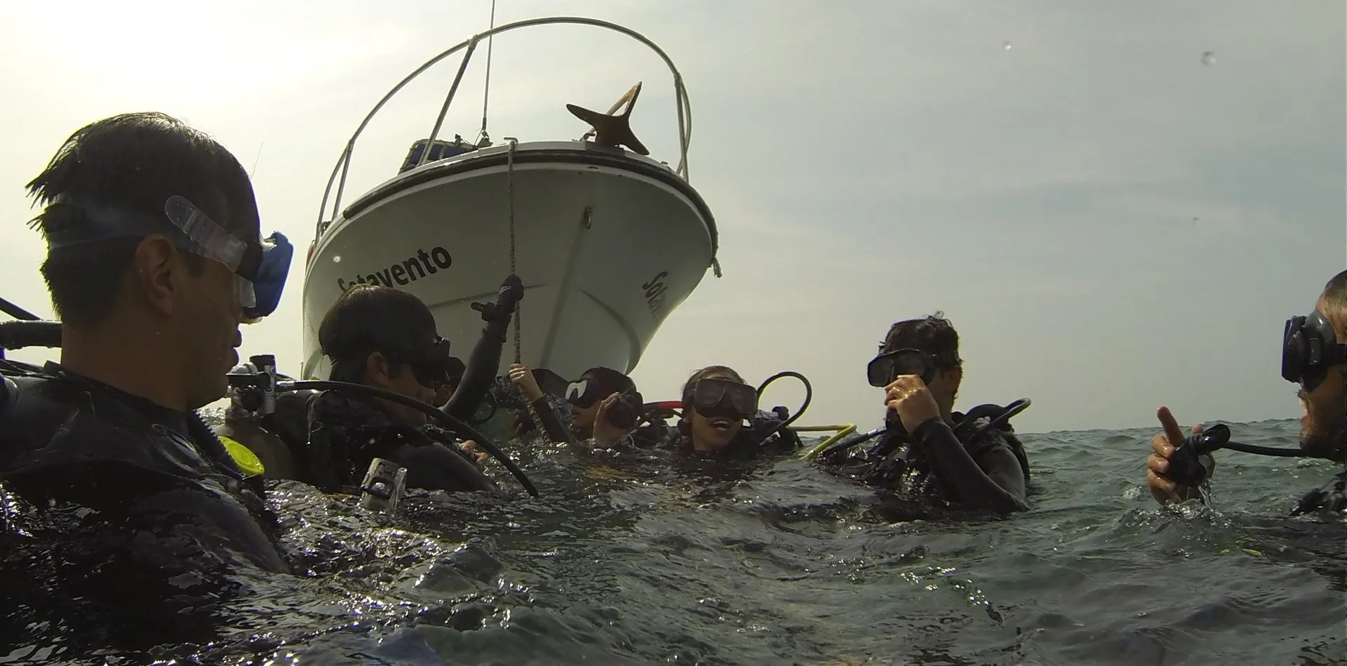 Group of divers at the surface next to the boat after a dive